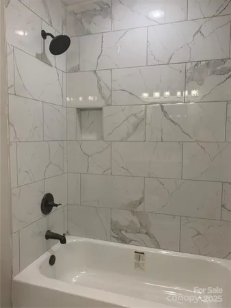 a bathroom with a white bath tub and a shower