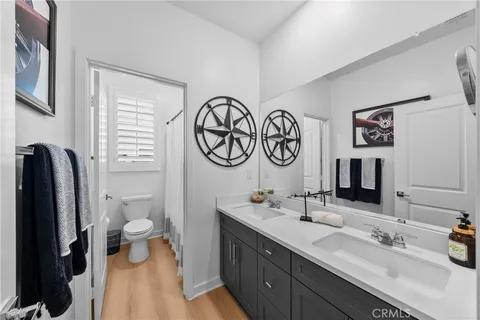 a bathroom with a double vanity sink mirror and toilet