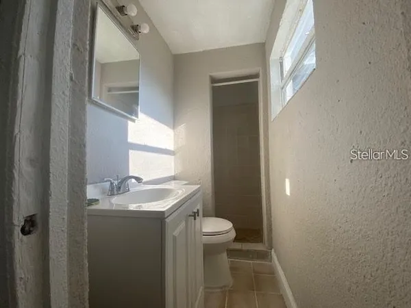 a bathroom with a granite countertop sink a toilet and a mirror