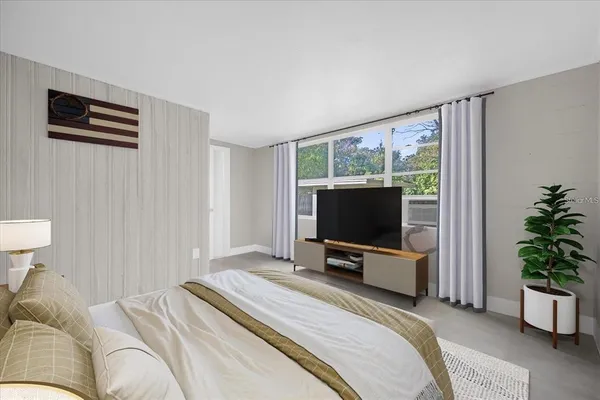 a bedroom with a bed and a flat screen tv