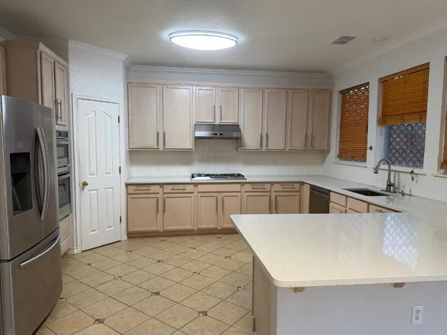 a kitchen with granite countertop a refrigerator sink and stove
