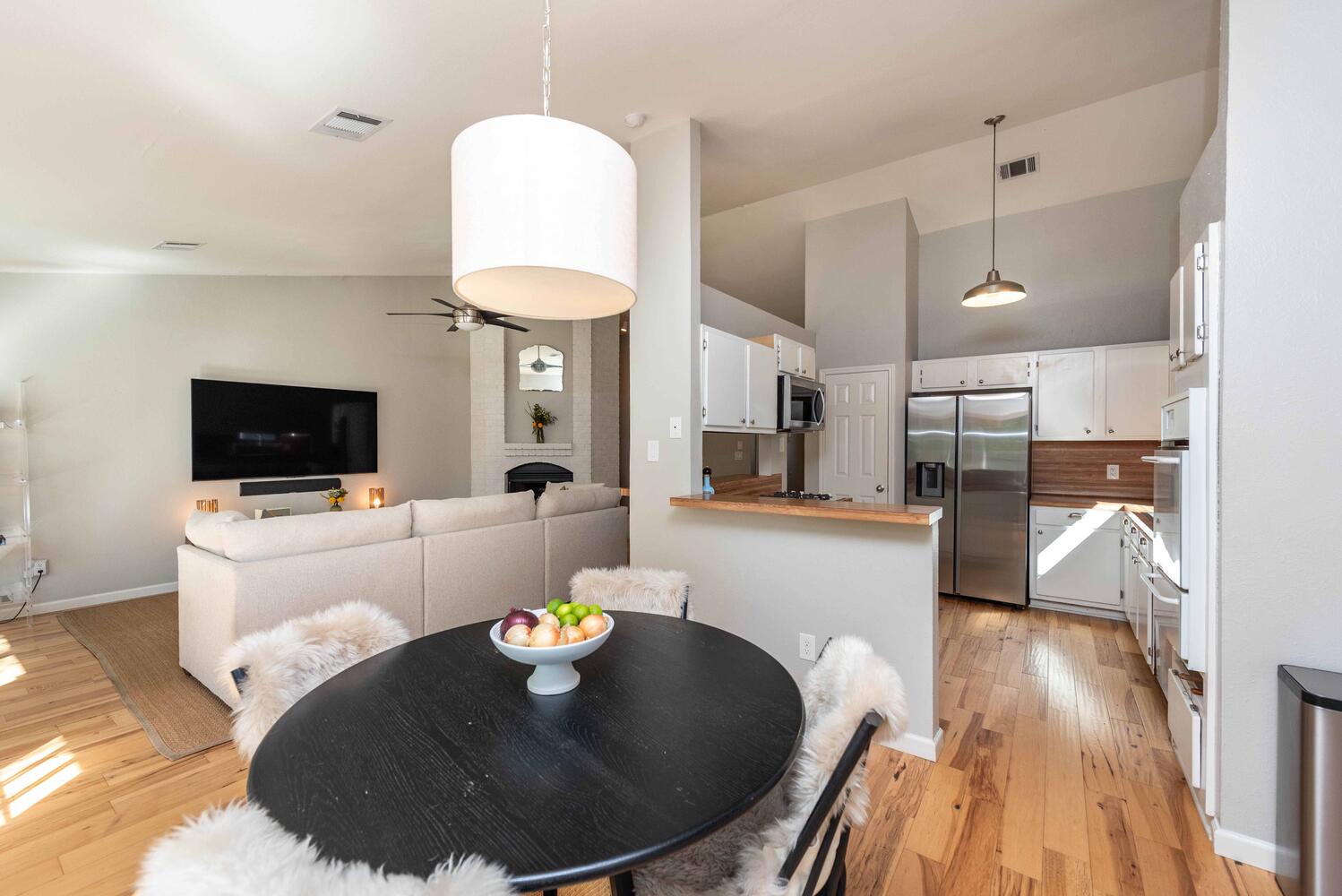 3403 Palomar Lane Austin, TX 78727 - Photo 11 of 33 Dining room with ceiling fan, a large fireplace, vaulted ceiling, and light wood-type flooring