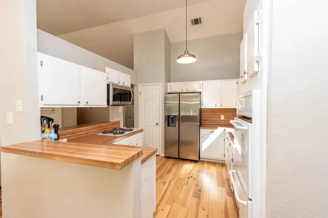 a view of a kitchen with a sink and refrigerator