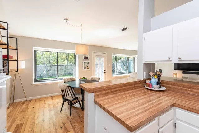 a kitchen with a table chairs and wooden floor