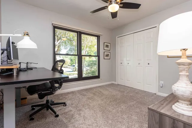 a view of a workspace with furniture and a window