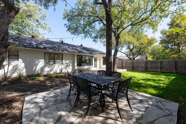 a view of a table and chairs in backyard of the house