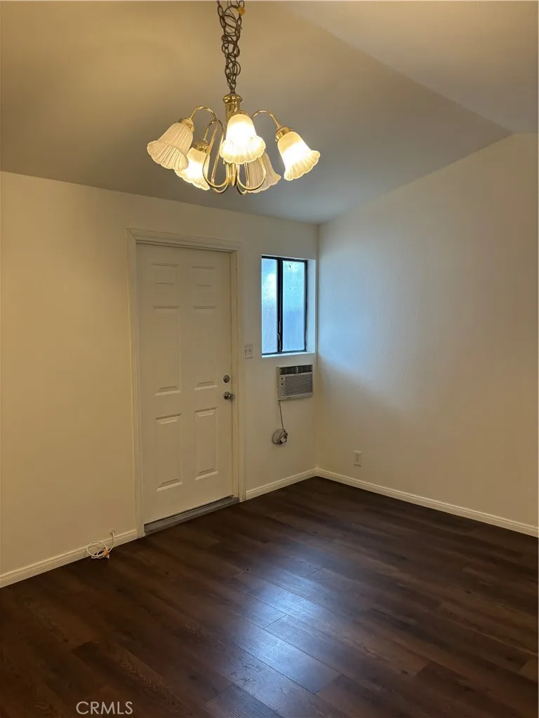 24627 Moon Avenue Lomita, CA 90717 - Photo 2 of 7 a view of an empty room with wooden floor and a chandelier