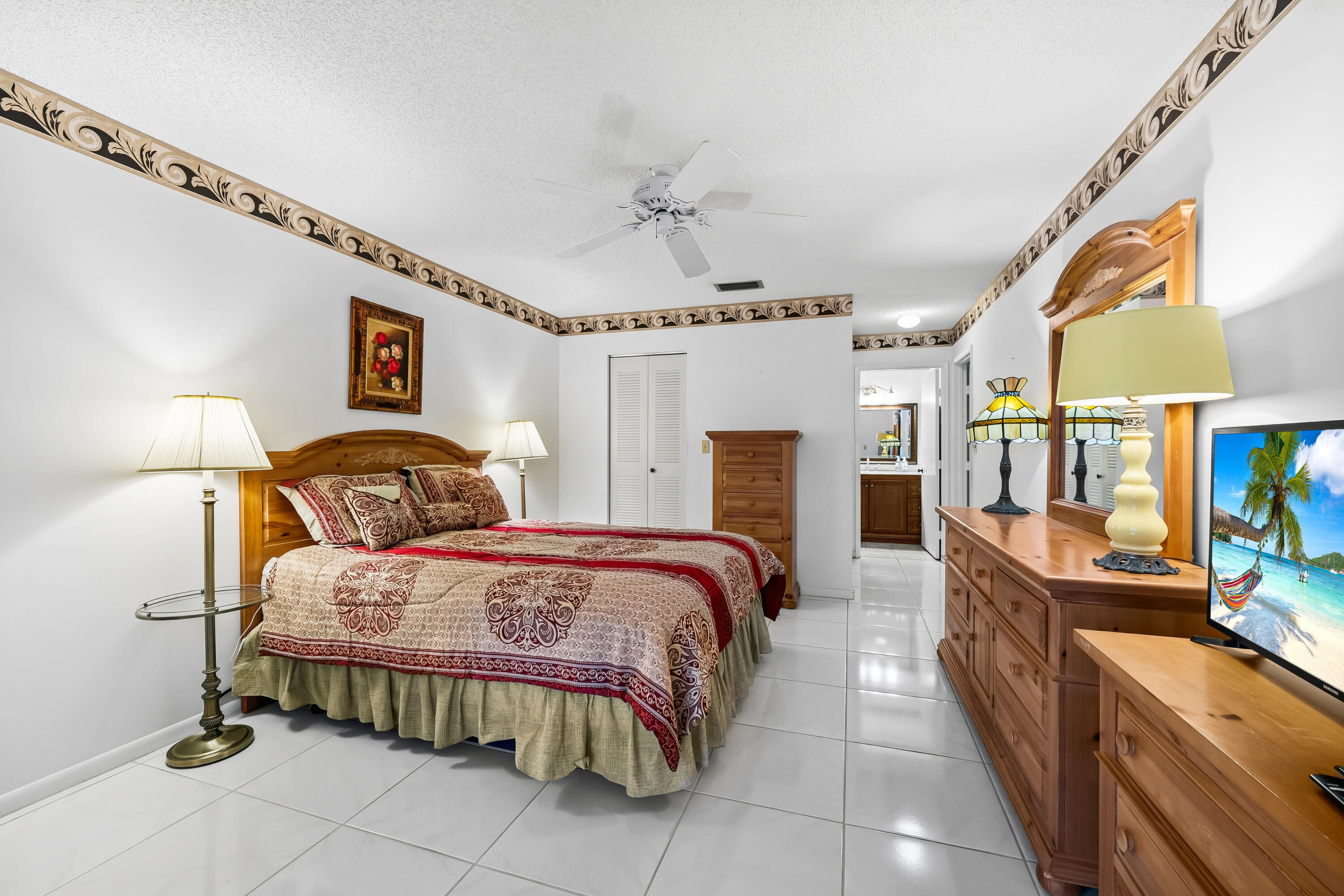 18762 Candlewick Drive Boca Raton, FL 33496 - Photo 38 of 52 a spacious bedroom with a bed and a chandelier