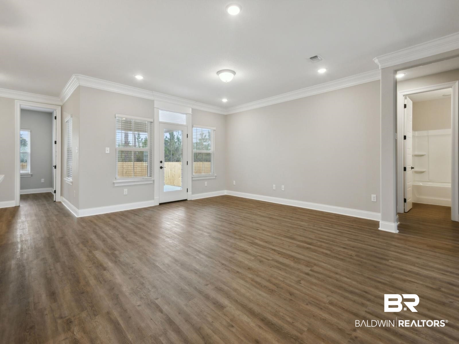 12942 Gondala Street Elberta, AL 36530 - Photo 8 of 18 Unfurnished living room featuring ornamental molding, dark wood finished floors, and recessed lighting