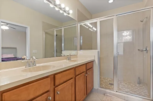 a bathroom with a double vanity sink mirror and shower