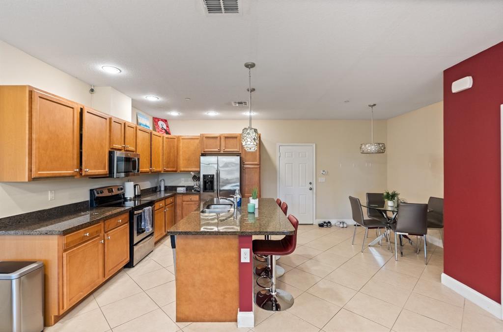 4025 Cascada Circle Hollywood, FL 33024 - Photo 5 of 19 a kitchen with stainless steel appliances kitchen island granite countertop a stove a sink and a refrigerator