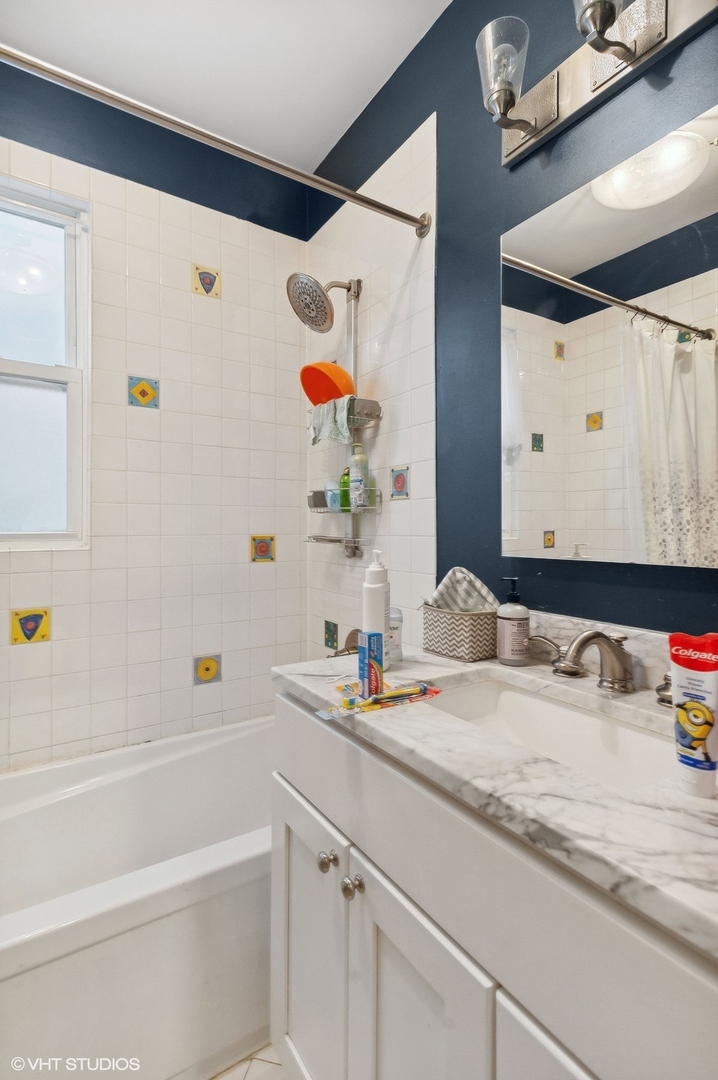 3838 North Wayne Avenue Chicago, IL 60613 - Photo 25 of 40 a bathroom with a bathtub sink and mirror