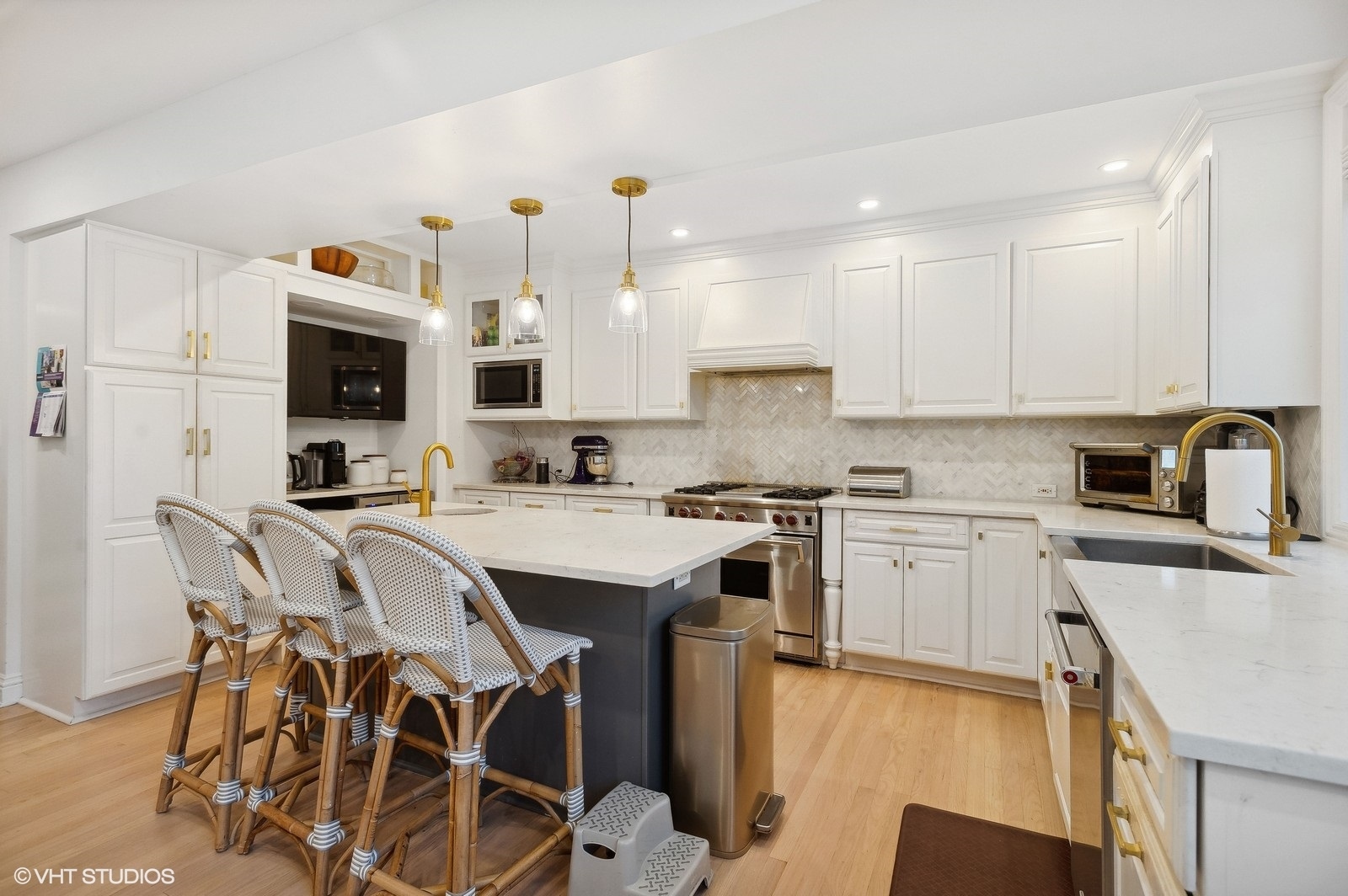 3838 North Wayne Avenue Chicago, IL 60613 - Photo 3 of 40 a kitchen with a sink stove and white cabinets with wooden floor