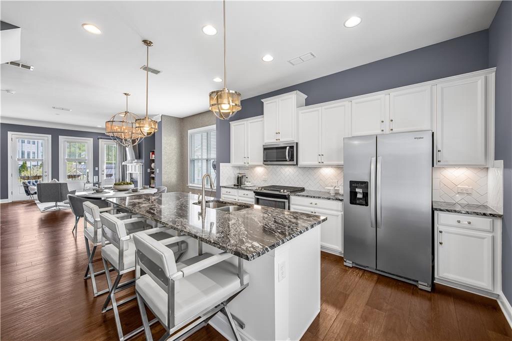 2013 Rockledge Road Northeast Atlanta, GA 30324 - Photo 12 of 50 a kitchen with stainless steel appliances granite countertop a stove refrigerator a dining table and chairs with wooden floor