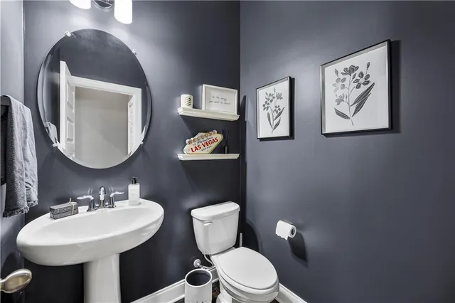 a view of a hallway with wooden floor and a bathroom