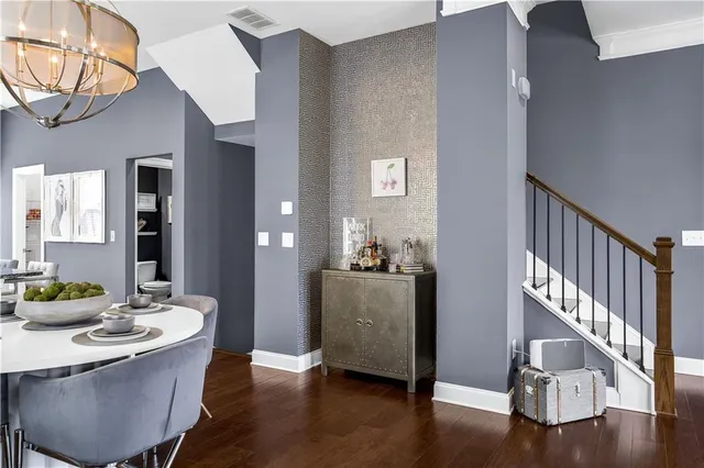 a kitchen with stainless steel appliances kitchen island granite countertop a stove a refrigerator a kitchen island a sink and white cabinets with wooden floor