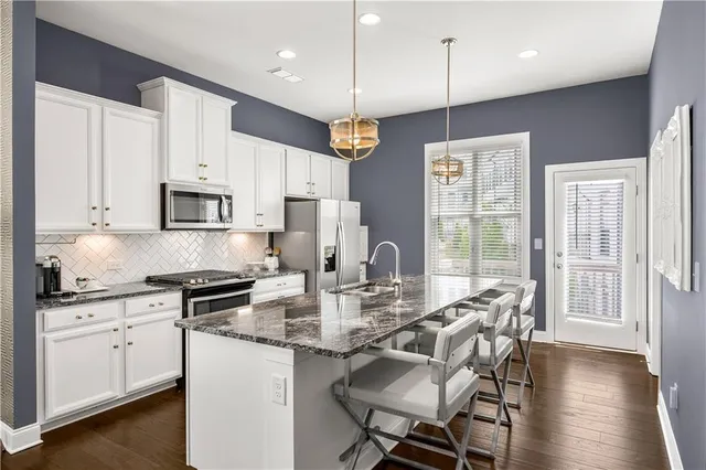 a kitchen with granite countertop a sink cabinets and wooden floor