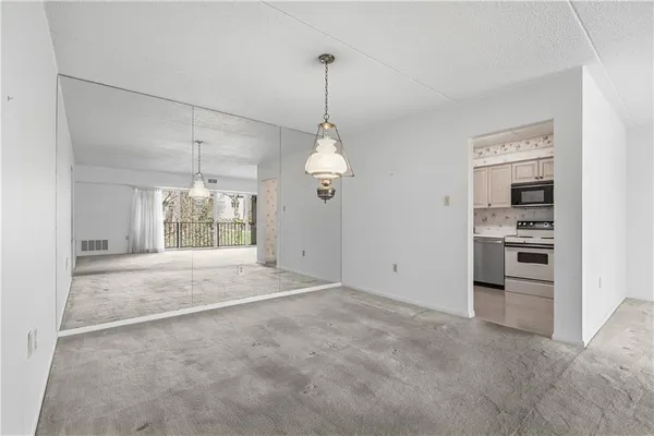 a kitchen with stainless steel appliances granite countertop white cabinets a stove a microwave and a refrigerator