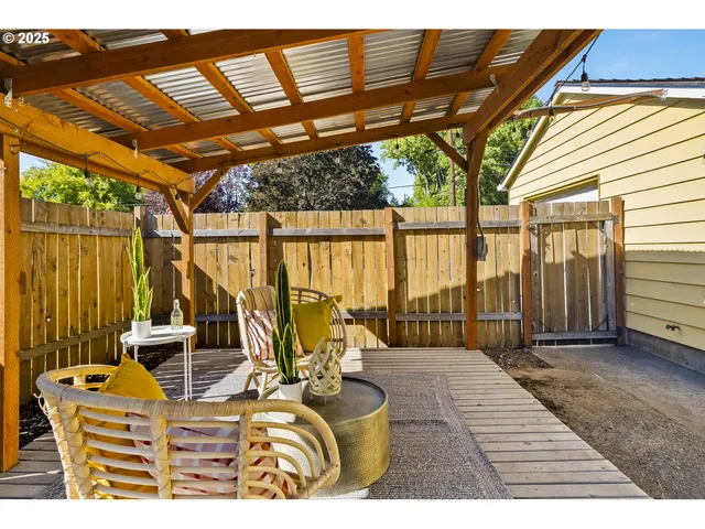 a view of a patio with couches chairs and wooden floor
