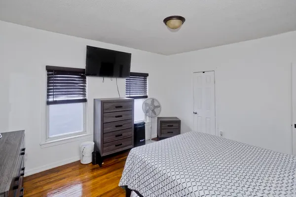 a bedroom with a bed and a flat tv screen on the dresser