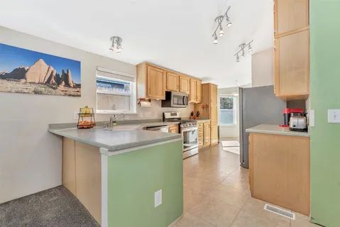 a kitchen with stainless steel appliances a sink a stove and a refrigerator