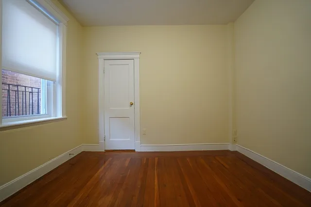 a view of a room with wooden floor and window
