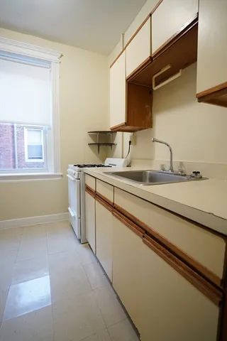 a kitchen with a sink and a wooden cabinets