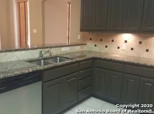 a kitchen with granite countertop a sink and cabinets