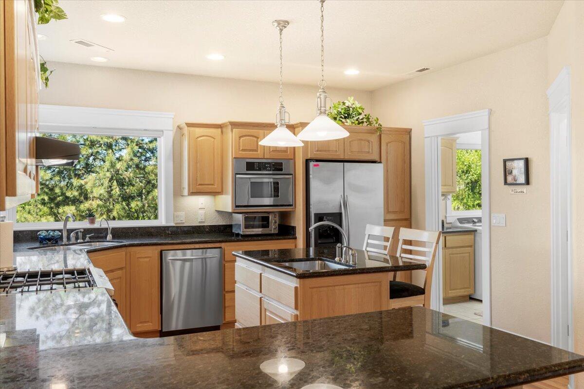 3344 Pearce Park Road Grants Pass, OR 97526 - Photo 25 of 65 Kitchen has island with seating, sink with disposal and granite counter tops.