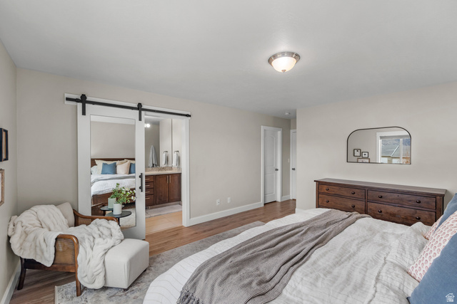 1896 West 800 North Mapleton, UT 84663 - Photo 15 of 55 Bedroom featuring a barn door, wood finished floors, and ensuite bathroom