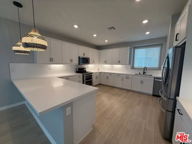 a large room with kitchen view and a fireplace