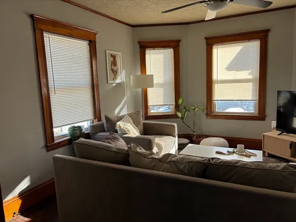 a living room with furniture and two window