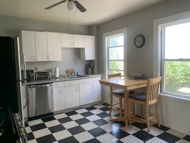 a kitchen with a checkered floor and white cabinets
