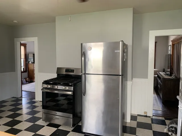 a kitchen with a refrigerator and a stove top oven
