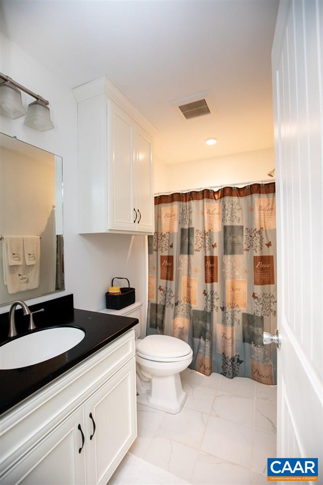 962 School Road Farmville, VA 23901 - Photo 23 of 41 a bathroom with a granite countertop sink a toilet a mirror and shower