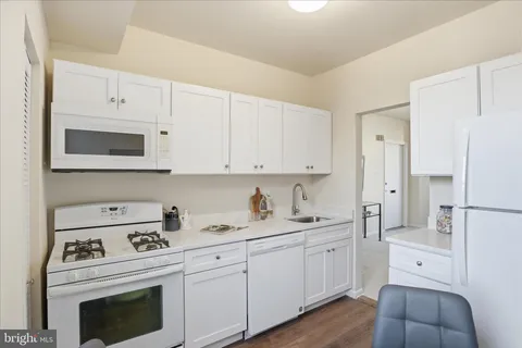 a kitchen with cabinets appliances a sink and a counter top space
