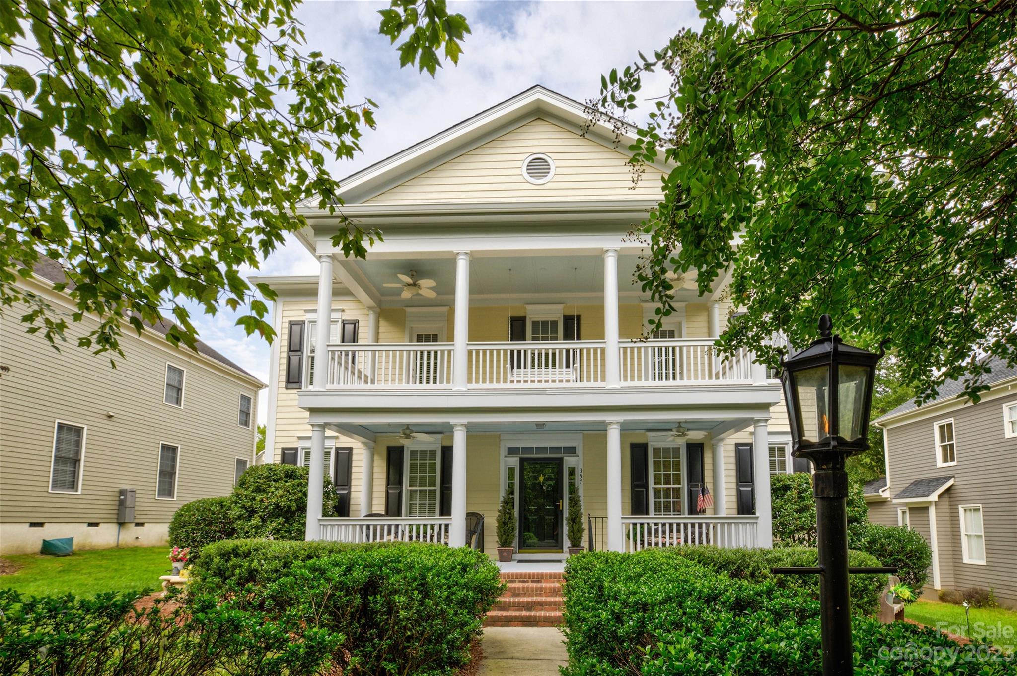 a view of a white house with large windows and a tree