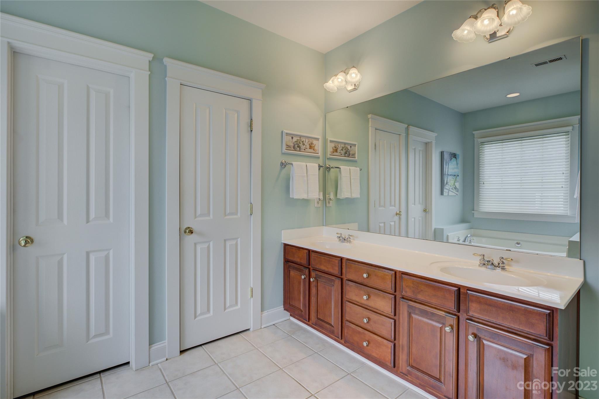 357 Elis Way Fort Mill, SC 29708 - Photo 33 of 48 a spacious bathroom with a double vanity sink a mirror and a shower