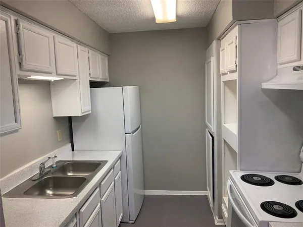 a kitchen with stainless steel appliances a sink a refrigerator and cabinets