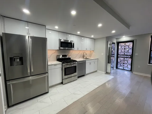 a kitchen with stainless steel appliances a refrigerator stove microwave and cabinets