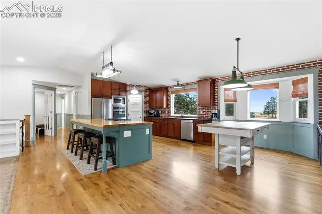 a living room with furniture a dining table wooden floor and a fireplace