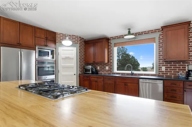 a kitchen with kitchen island granite countertop a stove cabinets and wooden floor