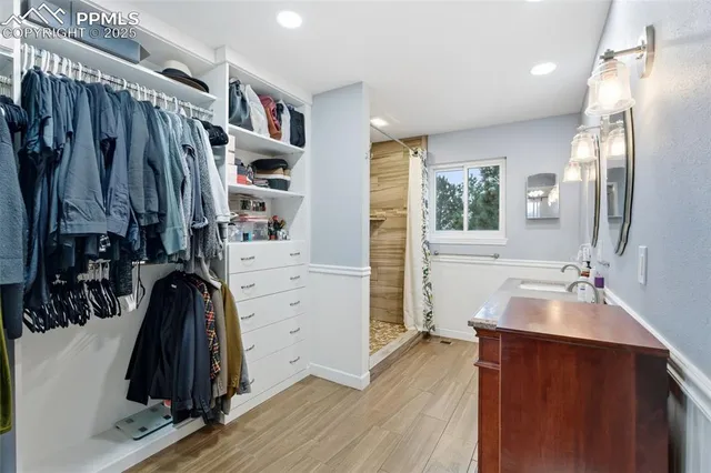 a view of walk in closet with clothes and shoes