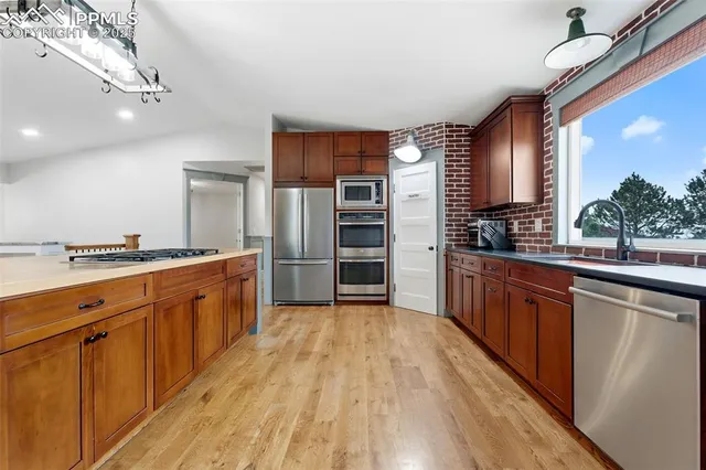 a large kitchen with kitchen island granite countertop a large counter top stainless steel appliances and cabinets