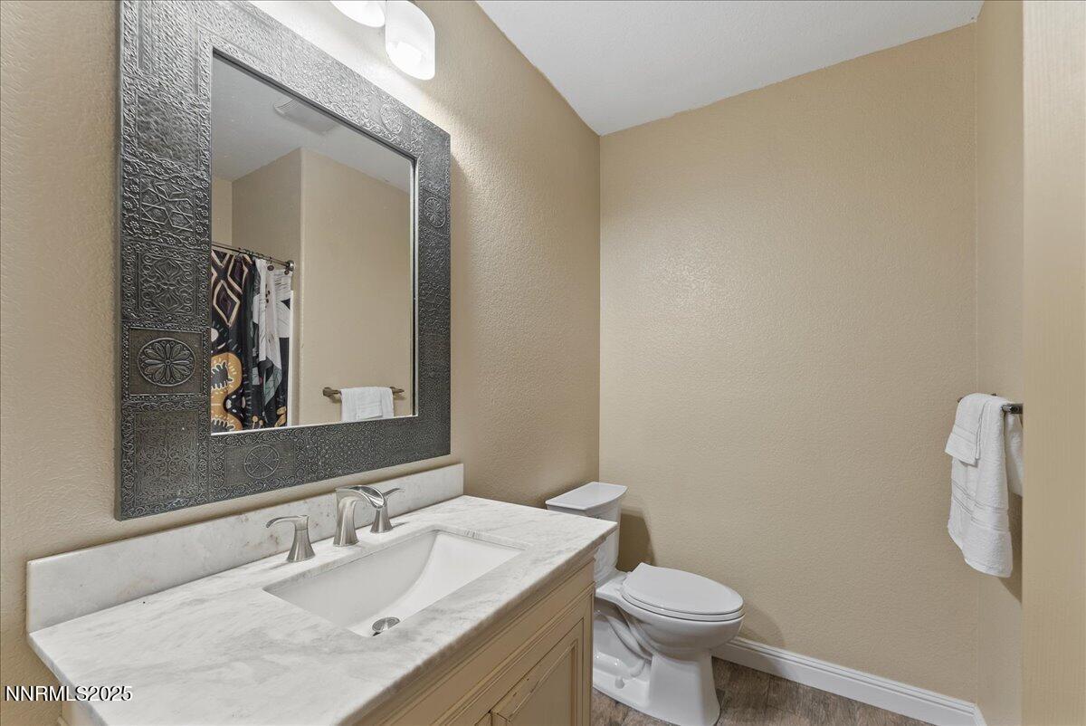 7245 Winterhill Court Reno, NV 89523 - Photo 20 of 25 a bathroom with a granite countertop sink a toilet and a mirror