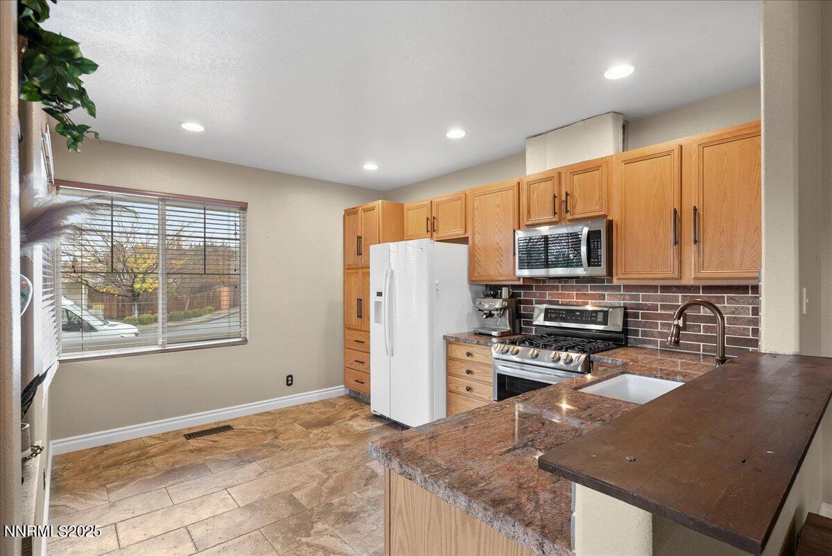 7245 Winterhill Court Reno, NV 89523 - Photo 8 of 25 a kitchen with stainless steel appliances granite countertop a refrigerator stove microwave and sink
