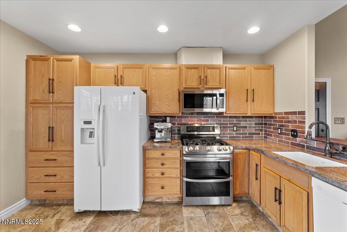 7245 Winterhill Court Reno, NV 89523 - Photo 10 of 25 a kitchen with refrigerator a stove and cabinets