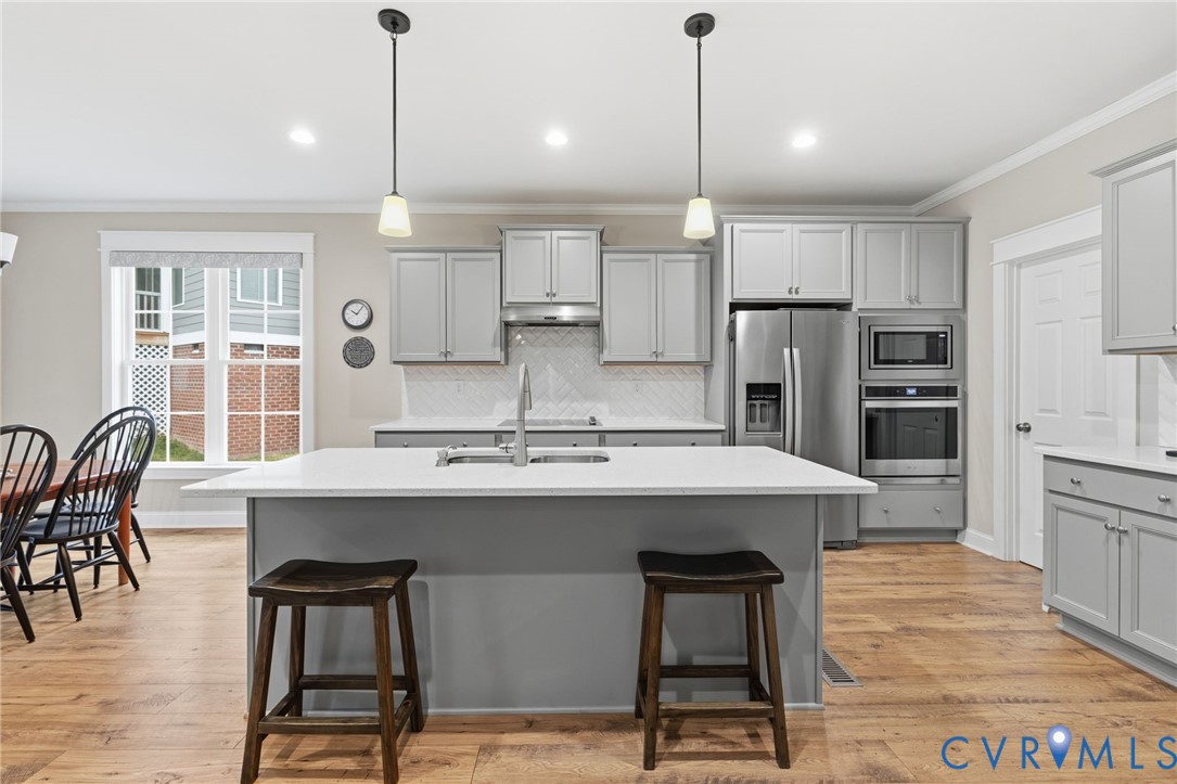 4001 Bircham Loop Midlothian, VA 23113 - Photo 8 of 33 a kitchen with stainless steel appliances kitchen island granite countertop a table chairs stove and refrigerator