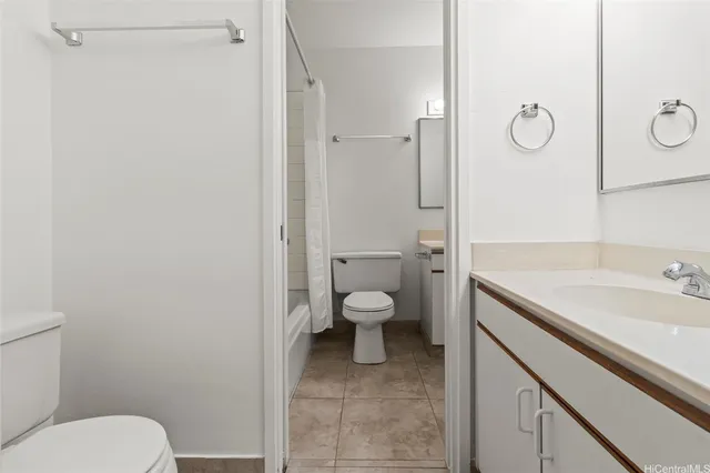 a bathroom with a granite countertop toilet a sink and a mirror