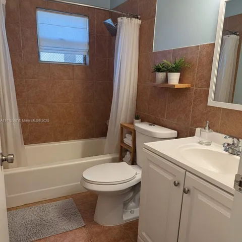 a white toilet sitting next to a bath tub